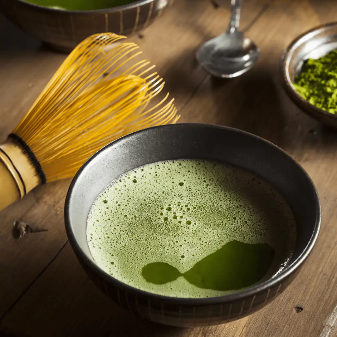 Traditionel matcha-te i sk&aring;l med bambuspiskeris og gr&oslash;nt matcha-pulver &ndash; japansk gr&oslash;n te klar til brygning.